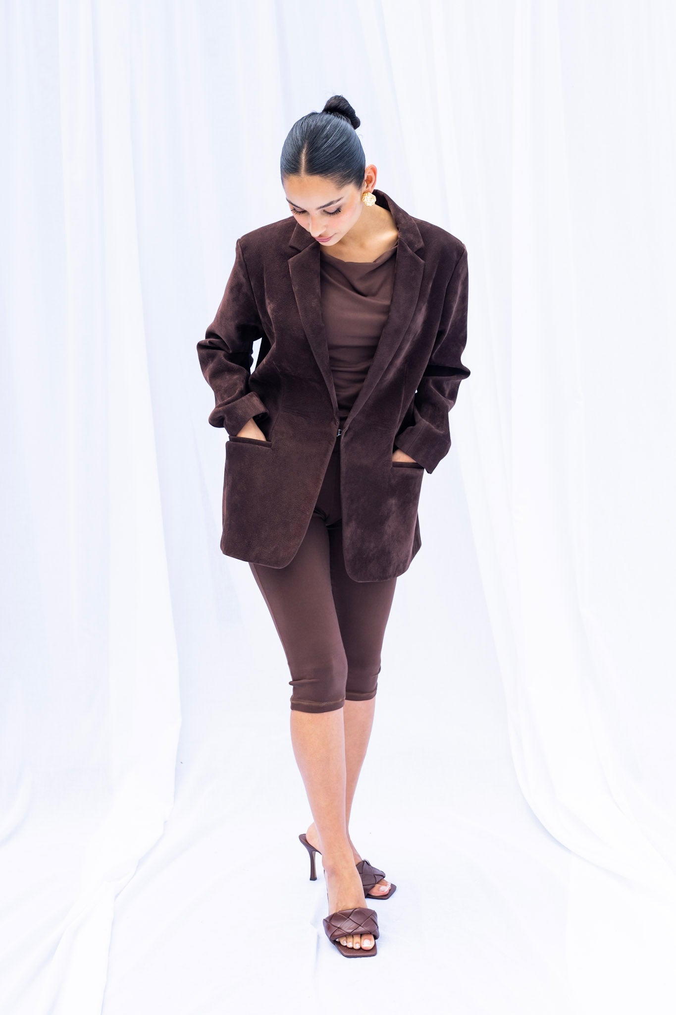 Woman wearing a brown suit with a white background