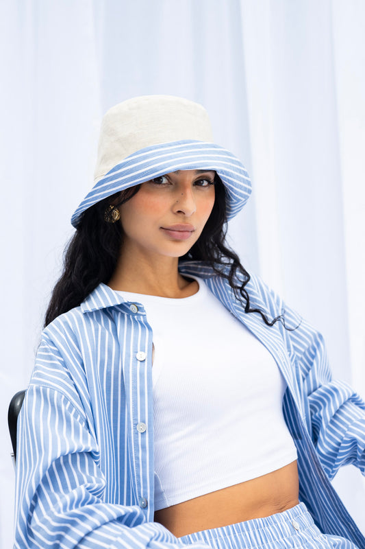 Woman wearing a blue and white striped hat and shirt against a white background